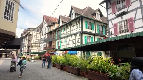 Visitors stroll through the charming streets of Bukit Tinggi French Village Stock Footage 337984762