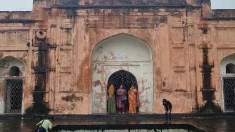Visitors take shelter from the rain at the Bibi Pari Mausoleum in Lalbagh Fort 库存影片 337969409