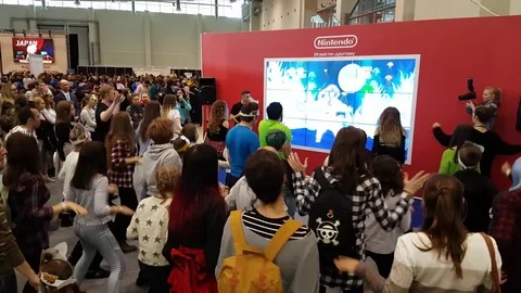 Visitors testing Nintendo dancing video game Stock Footage 75130594