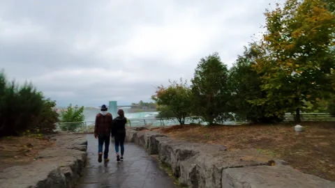 Visitors / Tourists walk down pathway to the waterfall views at Niagara Falls Stock Footage 141775401