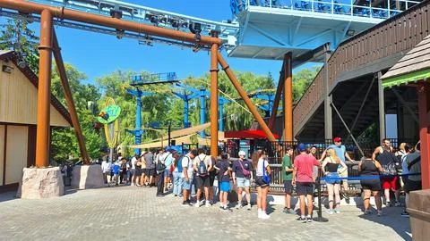 Visitors wait in line for a roller coaster ride. Stock Photos