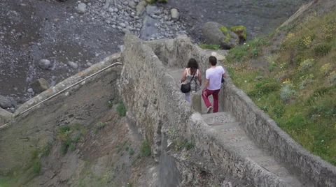 Visitors walk down the steps of San Juan de Gaztelugatxe Stock Footage 64293294