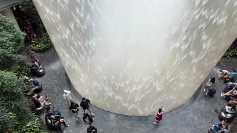 Visitors walk, relax, and take photos around the iconic HSBC Rain Vortex Stock Footage 340933214