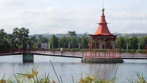 Visitors Walking on Red Bridge of Chinese Pagoda, Eden Garden Portugal Video stock 337405778