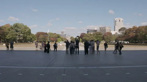 Visitors walking through of the Hiroshima Peace Memorial Park in Japan Stock Footage 335543104