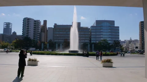 Visitors walking through of the Hiroshima Peace Memorial Park in Japan Stock Footage 335543596
