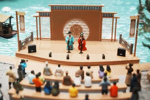 Visitors watch a theatrical performance on a large 3D-printed sand table at t Stock Photos