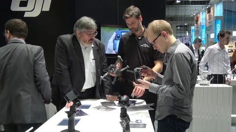 Visitors watching drones by DJI company on exhibition Cebit 2017 in Hannover Stock Footage 74144874