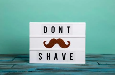 Visual Lightbox with the words dont shave and a bogite on turquoise green bac Stock Photos