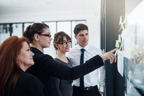 Visualising all their feasible options. a group of businesspeople brainstorming Foto stock