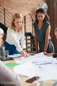 Visualising something bigger. a group of architects working with blueprints in Foto stock