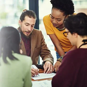 Visualising their plans on paper. a group of young creatives having a meeting in Foto stock