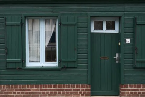 A visually appealing and charming green wooden door that features a matching  Stock Photos