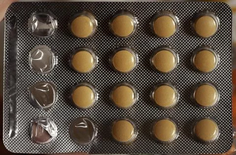 Vitamin B complex orange tablet pills in a blister, health, closeup Stock Photos