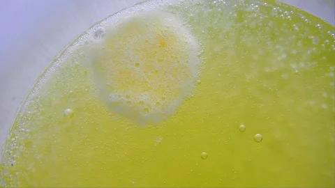 Vitamin C tablet is thrown into a transparent glass with water. Macro Close up Stock Footage 128571460