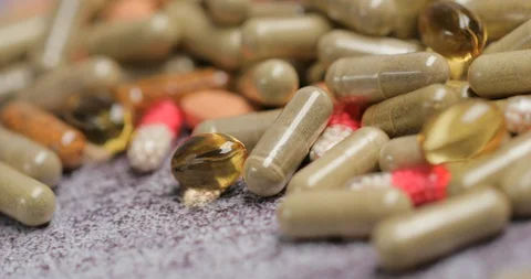 Vitamin capsules lie on a table Stock Footage 127841827