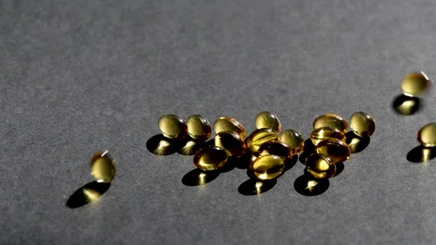 Vitamin D capsules pour on top. black background. Biologically active additives Stock Footage 149182804