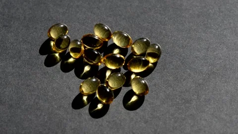 Vitamin D capsules pour on top. black background. Biologically active additives Stock Footage 149183211