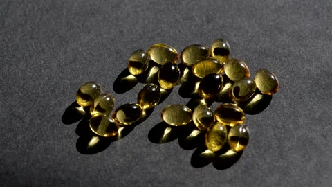 Vitamin D capsules pour on top. black background. Biologically active additives Stock Footage 149402152