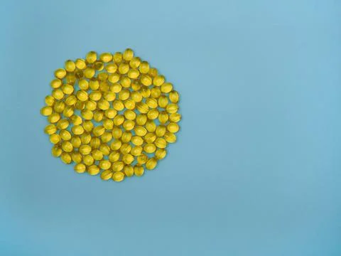 Vitamin D, E, omega 3, 6, 9 on a blue background with space for text, top view Stock Photos