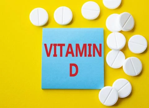 Vitamin D symbol. Concept word Vitamin D on blue note. Beautiful yellow bac.. Stock Photos
