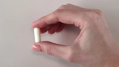 Vitamin D3 plus K2 in a woman's hand one capsule Stock Footage 235172904