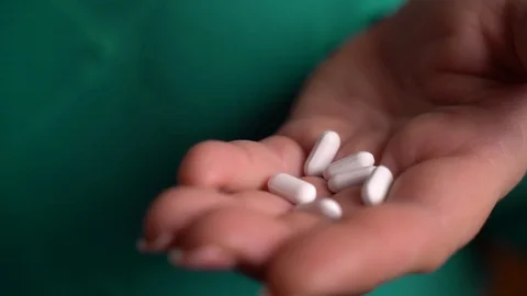 Vitamins And Supplements. Closeup of hand holding variety of white pills on palm Stock Footage 128645051