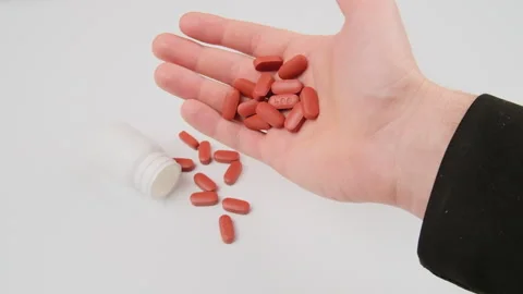 Vitamins and supplements. Man takes orange vitamin pills or medicine in hands, a Stock Footage 277621073