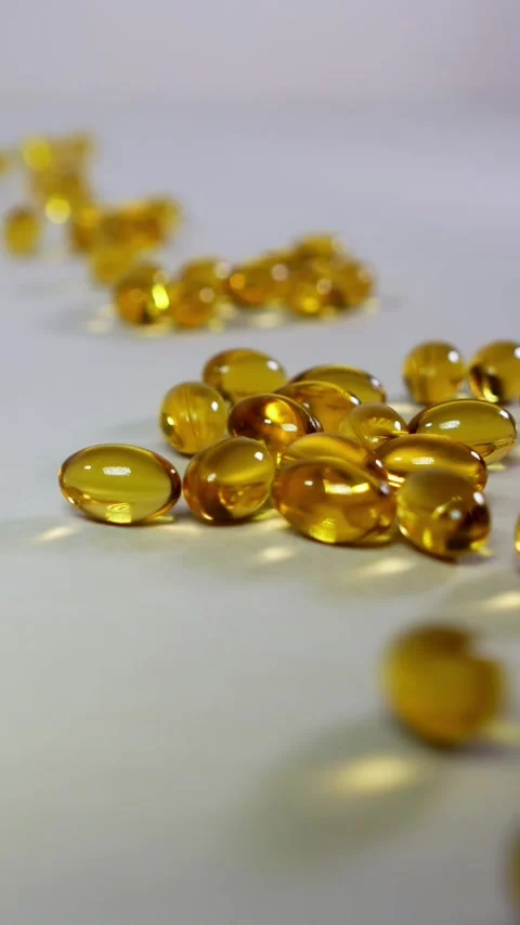Vitamins D and Nutritional supplements fall onto a white surface. Stock Footage 297859420