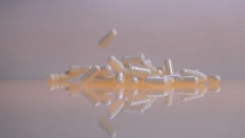Vitamins falling on reflective surface, slow motion Stock-Footage 88742571