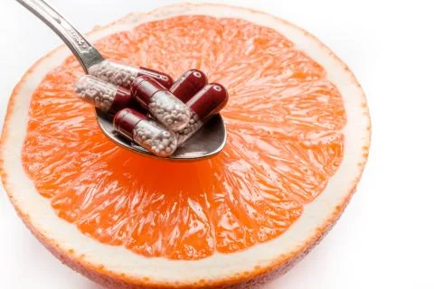 Vitamins in a spoon, lying on a grapefruit. 写真素材
