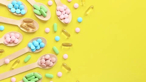 Vitamins on a yellow background, top view. Pills of different colors Video stock 247503822