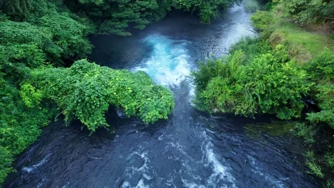 Vivid blue mountain stream water rushing over rocks Stock Footage 341175368