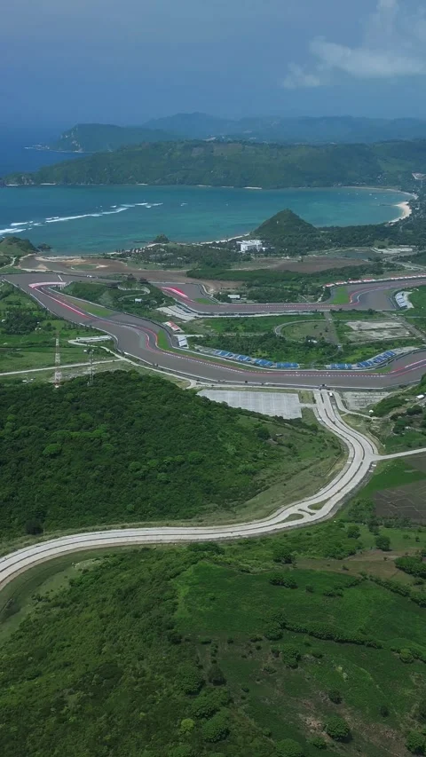 Vivid Blue Tones Highlight Winding Seaside Roadway From Above Video stock 331541411