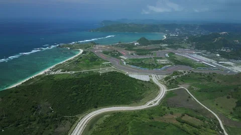 Vivid Blue Tones Highlight Winding Seaside Roadway From Above 스톡 동영상 334010750