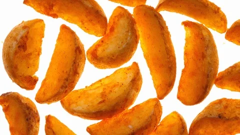 Vivid closeup top view of fried potato wedges rotating on white background. 4K. Vidéo 86098504