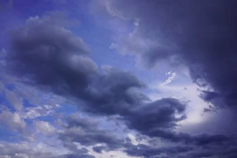 Vivid deep blue sky backdrop with dramatic white and dark storm clouds at s.. Stock Photos