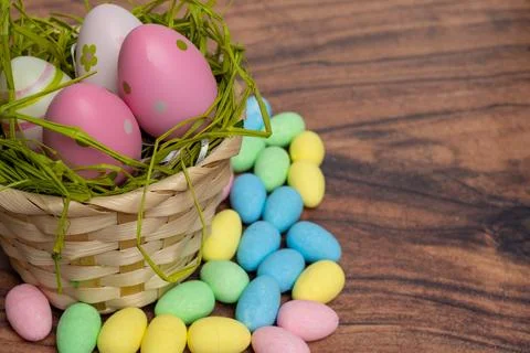 Vivid Easter Display Featuring Overflowing Basket And Treats On Wooden Surface Stock Photos