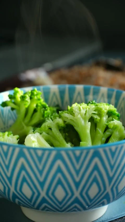 Vivid green broccoli side served hot in decorative blue ceramic bowl under Stock Footage 337546309