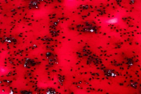 Vivid jam display. Detailed macro shot of shimmering red berry spread with seeds 库存照片