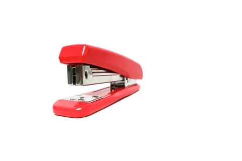 A vivid red stapler isolated on a pristine white backdrop, showcasing its f.. Stock Photos