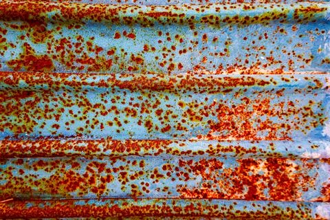 Vivid rust patterns on weathered blue metal surfaces create a stunning visu.. Stock Photos