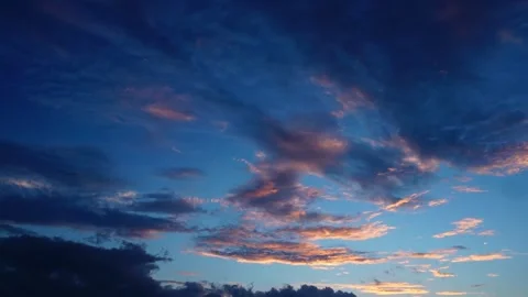 Vivid sunset clouds drifting slowly across a deep blue evening sky background Stock Footage 342221660