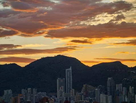 Vivid sunset scene, evening sky paints vibrant picture with towering mountains Stock Photos