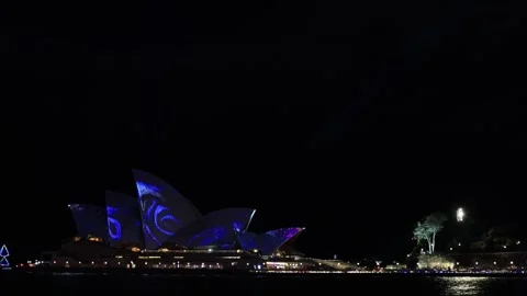 Vivid Sydney light show over harbour and city landmarks in Australia as 4k. Stock Footage 243355952