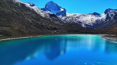 Vivid Turquoise Alpine Lake Surrounded by Majestic Snow Peaks China Stock Footage 346576056