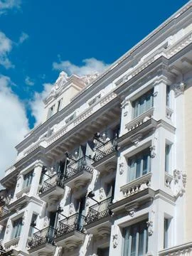 Vivid white facade of the classical building in downtown district of Madrid.. Stock Photos