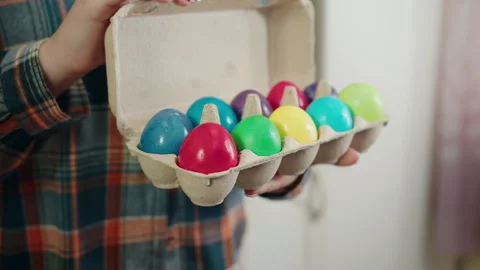 Vividly colored Easter eggs showcased in natural spring light in carton box Video stock 330492469