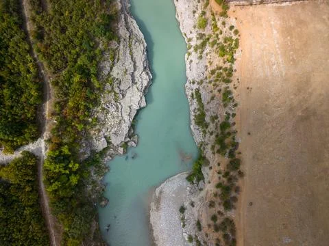 Vjosa River flows through rocky canyon in Albania, framed by forest and pale  写真素材