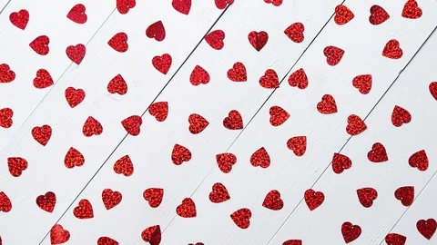 Vlentine's Day composition. Heart shaped sequins placed on white wooden table Stock Footage 101018968